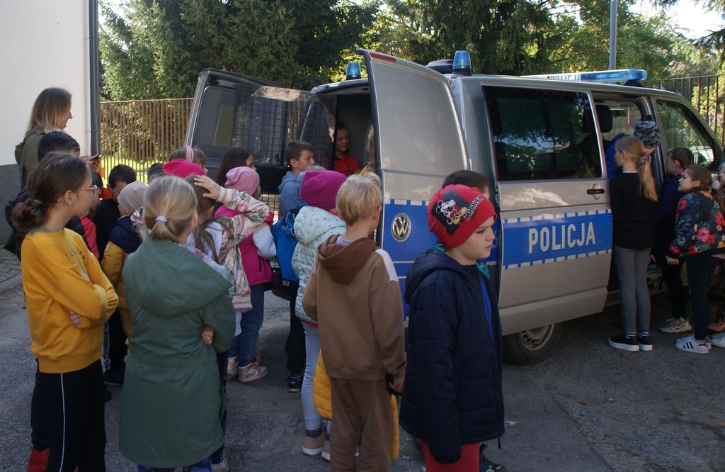 grupa dzieci oglądająca policyjny radiowóz 