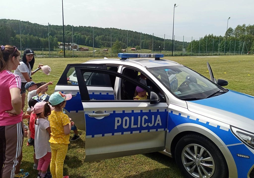policyjny radiowóz oraz stojące obok dzieci 
