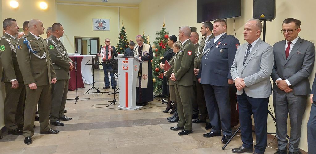 przemawia ksiądz biskup Marian Rojek, wokół stoją żołnierze  