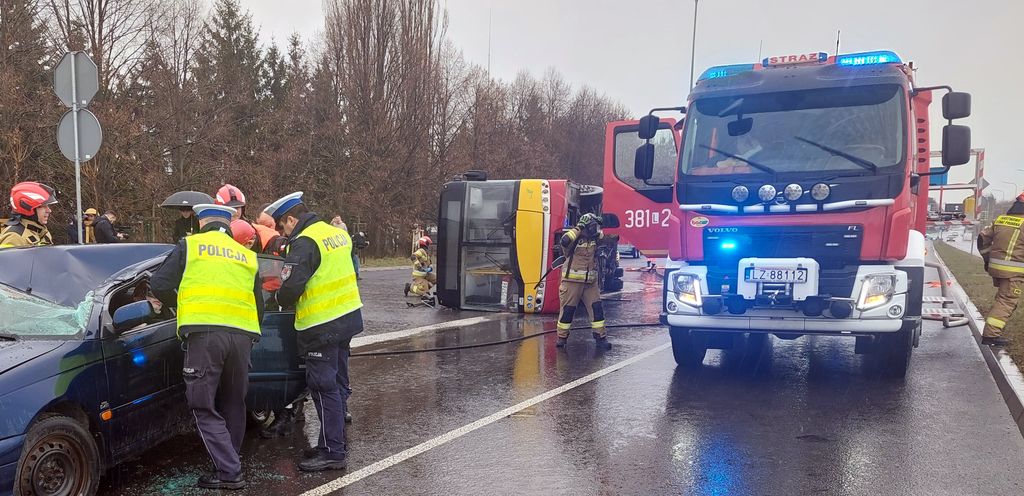 policjanci i strażacy wydostają rannego z samochodu 