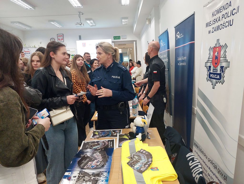 policjantka rozmawia z młodzieżą przy stoisku promocyjnym 