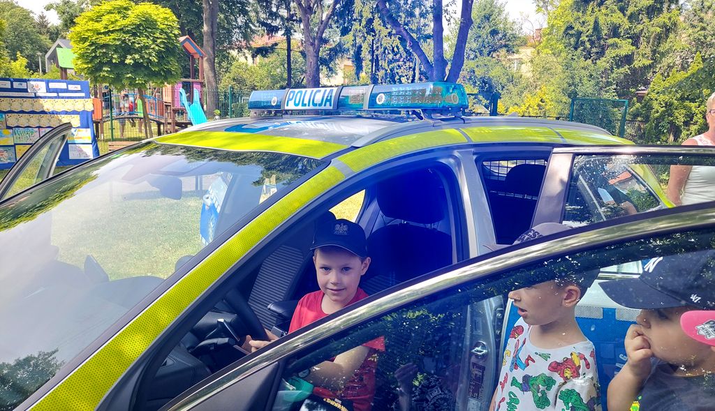chłopiec w policyjnym radiowozie w czasie spotkania profilaktycznego 