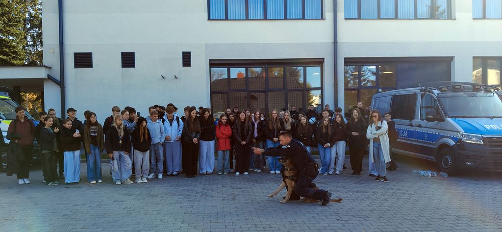 policjant z psem służbowym pokazuje młodzieży tresurę 