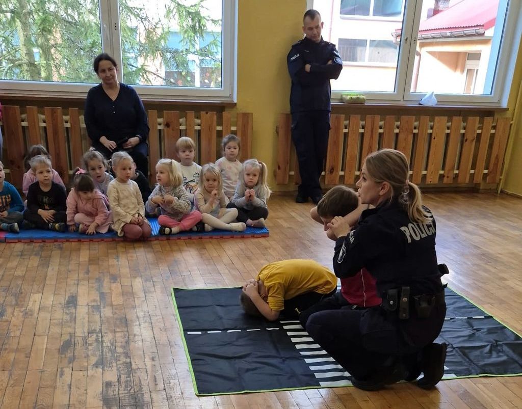 policjantka ćwiczy z dziećmi pozycję żółwia