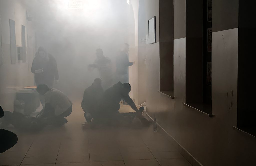 zadymiony korytarz szkoły i osoby ranne 