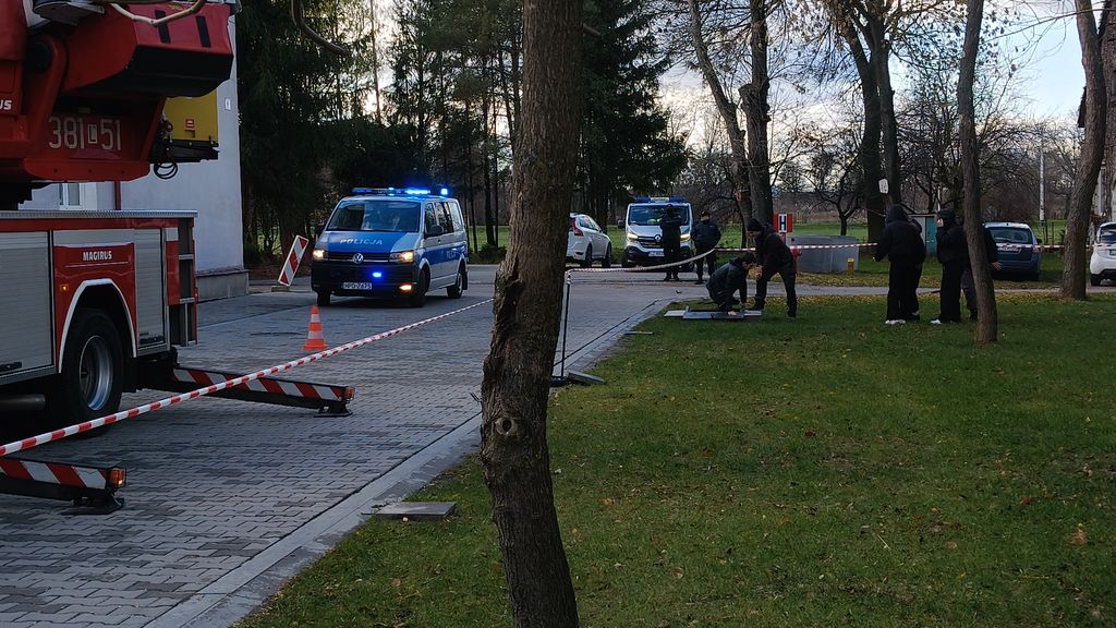 ćwiczenia, budynek szkoły przed którym stoi wóz strażacki i radiowóz 