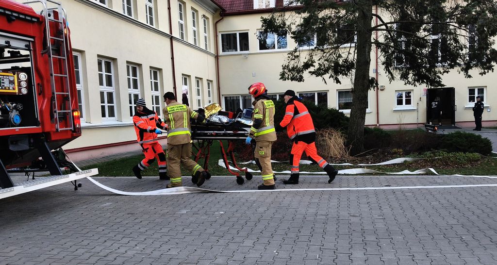 osoba ranna na noszach transportowych, którą wiozą ratownicy medyczni