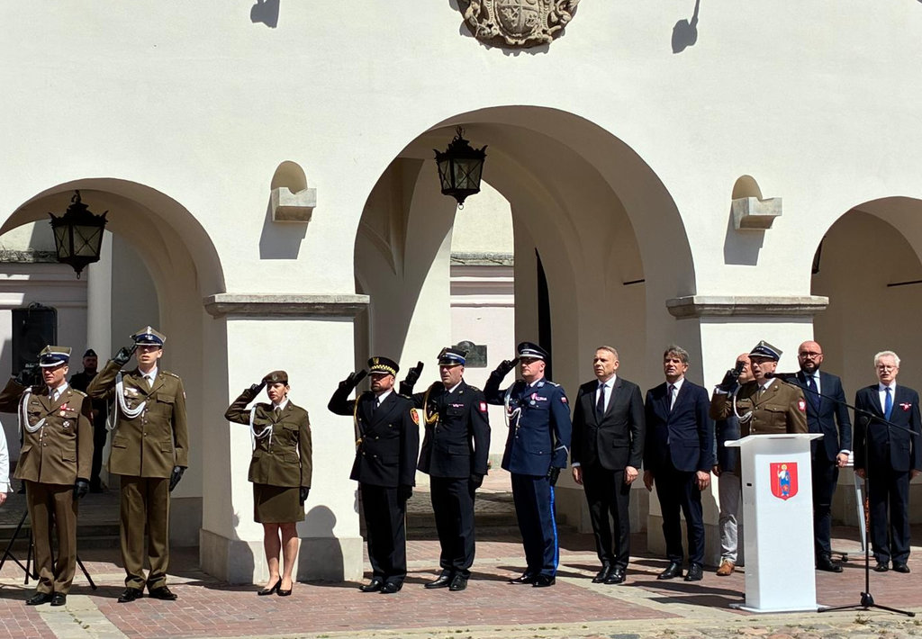 uczestnicy obchodów Dnia Flagi w Zamościu oddają honor w czasie hymnu Polski  
