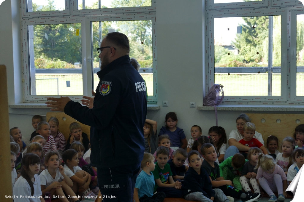 policjant podczas spotkania profilaktycznego rozmawia z uczniami