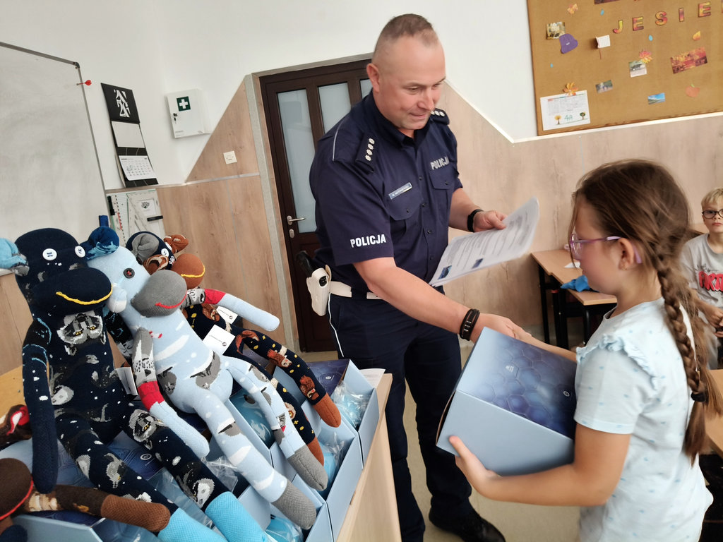 policjant rozdaje dziewicom kaski