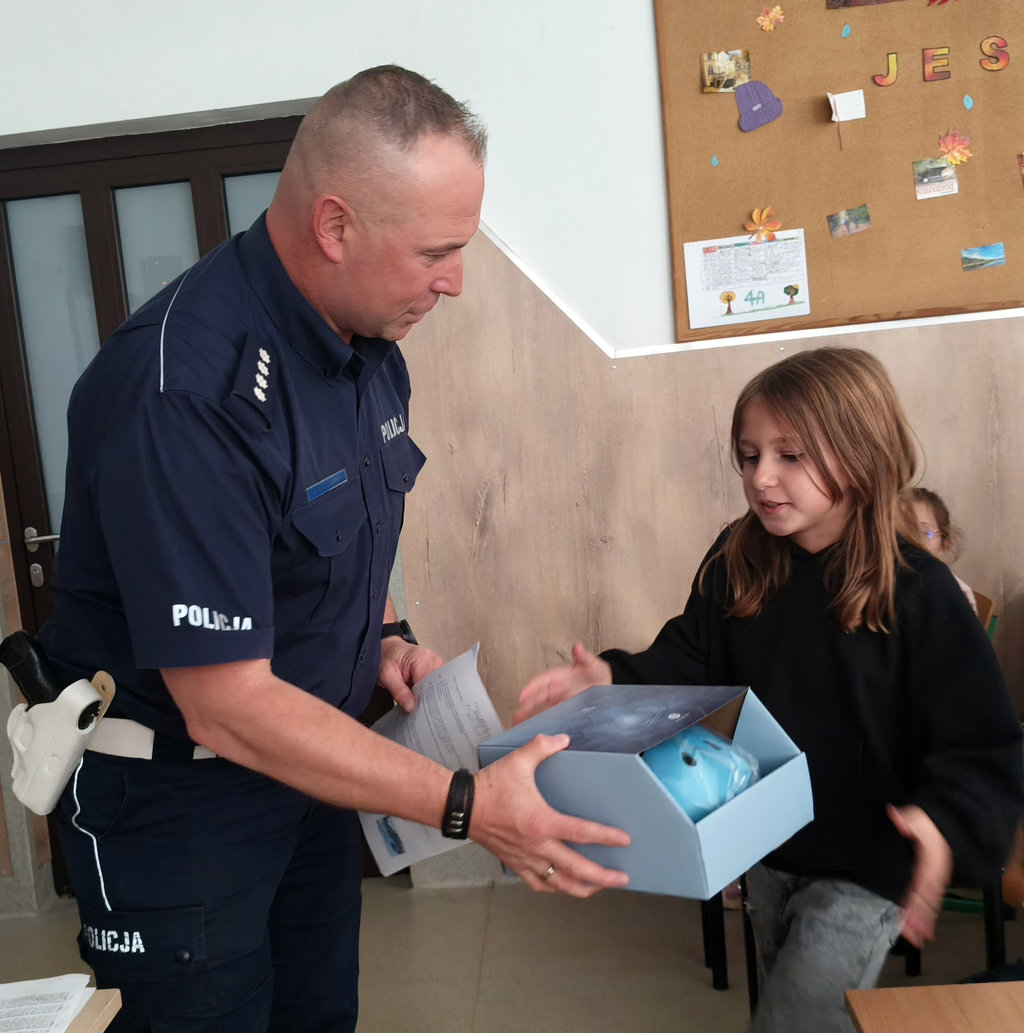policjant rozdaje dziewicom kaski