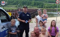 fot. policjant z osobami wypoczywającymi nad zalewem w Krasnobrodzie