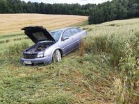 uszkodzony opel stojący w polu