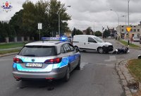 oznakowany radiowóz, w tle pojazd m. Dacia oraz leżący na jezdni motocykl m.Honda