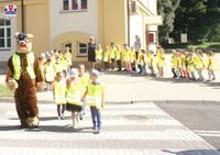 policyjna maskotka przeprowadza dzieci przez przejście