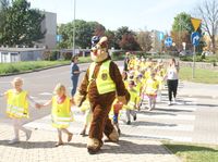 policyjna maskotka z dziećmi przechodzi przez przejście