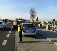 policjantka obok radiowozu w okolicach cmentarza