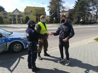 policjantka i funkcjonariusz WOT przekazują maseczkę mieszkańcowi Zamościa