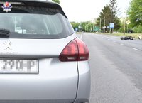 tył pojazdu marki Peugeot, w tle przewrócony na drogę motorower