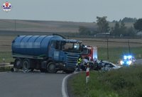 łuk drogi, stojąca w poprzek drogi ciężaróka, w rowie rozbity samochód osobowy, w tle radiowóz policyjny i wóz strażacki