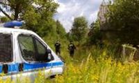 radiowóz, w tle widać dwóch policjantów