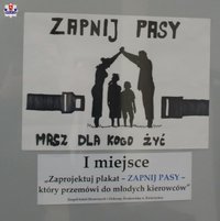 praca konkursowa, na białym tle czarne napisy zapnij pasy masz dla kogo żyć, na środku wizerunki dwóch osób dorosłych i dzieci, napis - I miejsce zaprojektuj plakat zapnij pasy.