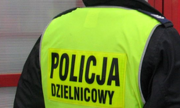 odwrócony plecami policjant w kamizelce z napisem Policja Dzielnicowy