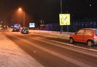 droga, stojące na poboczu osobowe fiaty, w tle policyjny radiowóz i policjanci