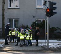 policjant i grupa dzieci z opiekunką przed przejściem