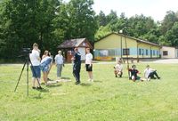 uczniowie i policjant na terenie plaży w Nieliszu w czasie kręcenia spotu