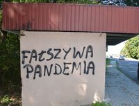 napis Fałszywa Pandemia naniesiony na ścianie przystanku