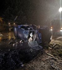 leżące na boku osobowe renault po uderzeniu w betonowy przepust