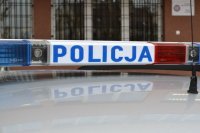 dach policyjnego radiowozu z napisem policja na tle krat