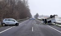 miejsce wypadku, stojący na poboczu pojazd marki Toyota Yaris, na przeciwległym poboczu leżący na dachu bus, na środku drogi stoi policyjny radiowóz