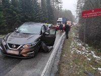 miejsce kolizji stojący na drodze uszkodzony nissan, w tle inne pojazdy