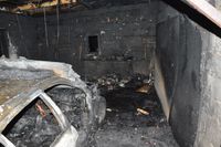 spalone wnętrze murowanego garażu oraz spalony bok znajdującego się wewnątrz samochodu osobowego