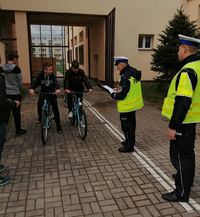 dwaj policjanci ruchu drogowego oraz dwaj uczniowie na rowerach w czasie konkursu