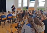 policjant w czasie spotkania z uczniami w szkole w Grabowcu