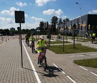 jadący po miasteczku rowerowym uczniowie w czasie egzaminu na kartę rowerową