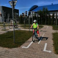 uczeń na rowerze podczas egzaminu na kartę rowerową jedzie uliczką miasteczka rowerowego