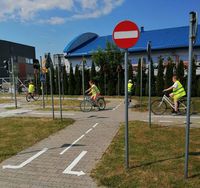 uczniowie podstawówek na rowerach podczas egzaminu na kartę rowerową jeżdżą uliczkami miasteczka rowerowego