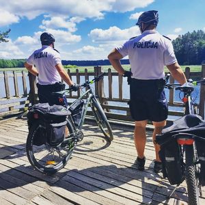 policjanci przy rowerach w tle jezioro