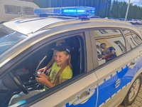 dziecko siedzące w policyjnym radiowozie