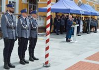 poczet flagowy podczas uroczystości święta Policji w tle przemawiający senator RP Jerzy Chróścikowski