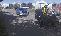 policyjne radiowóz i motocykl przed rozpoczęciem kolarskiego peletonu