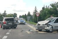 skrzyżowanie i stojące na ulicy dwa samochody osobowe uszkodzone w wyniku kolizji, w tle radiowóz