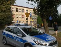 policjant w radiowozie zaparkowanym w okolicach szkoły