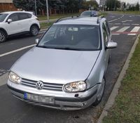 przy krawędzi jezdni stoi osobowy volkswagen, który ma uszkodzony lewy przedni bok