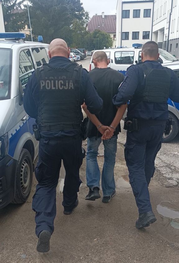 zatrzymany doprowadzany przez dwóch policjantów