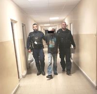 idący korytarzem zatrzymany wraz z dwoma policjantami